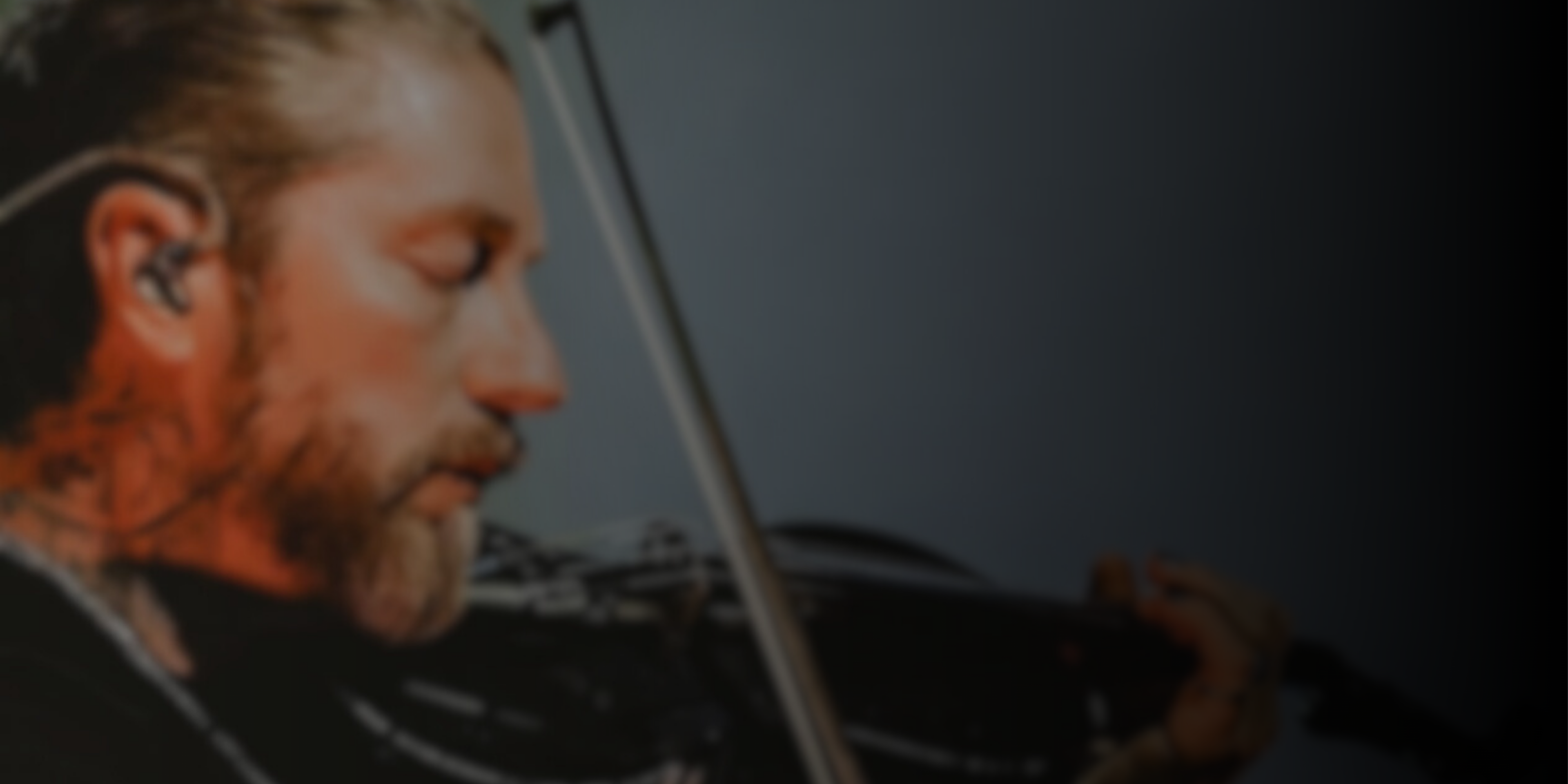 A blurred picture of Ryan Delahoussaye playing the violin